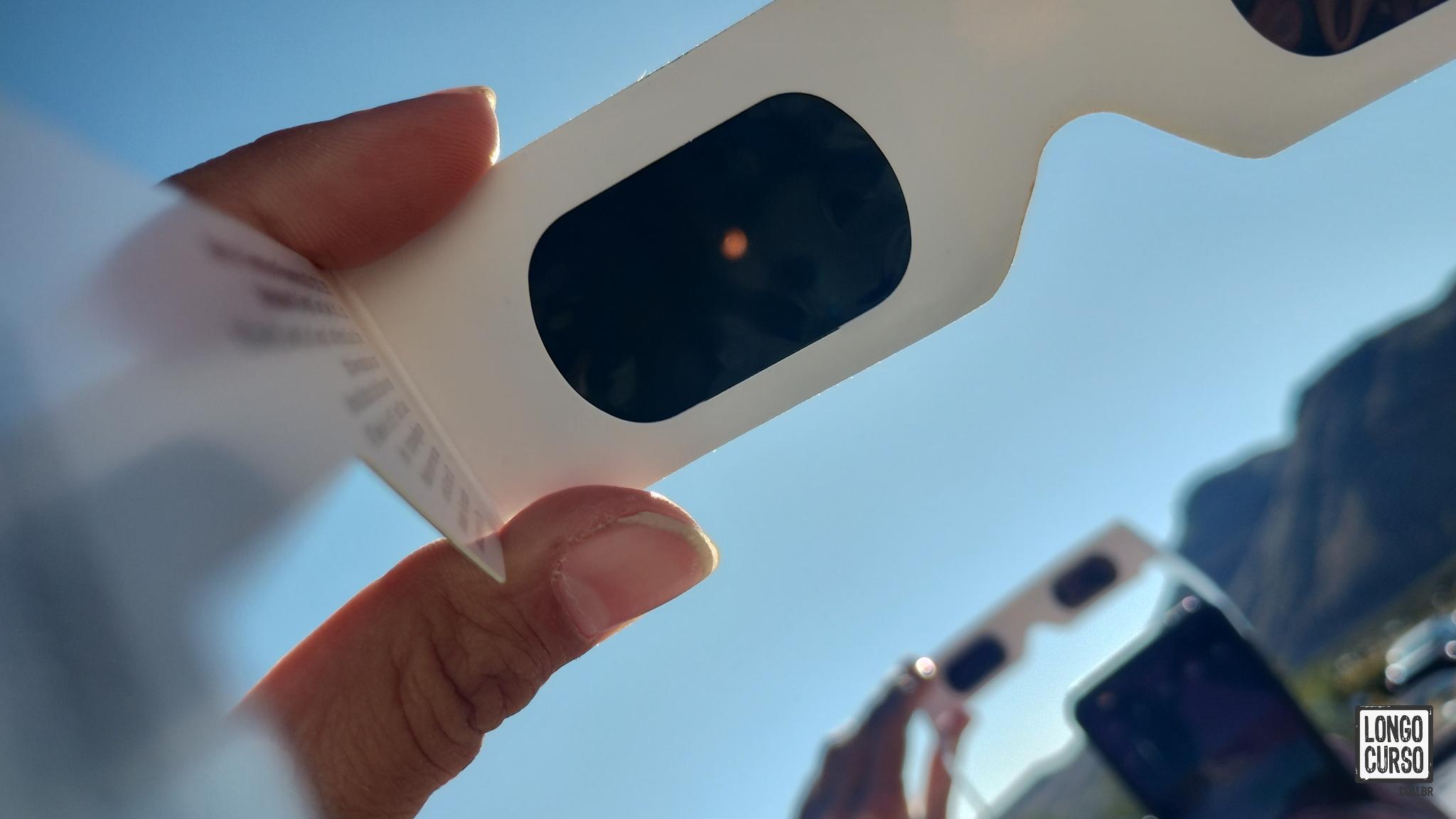 Tentando fotografar o eclipse através dos óculos protetores