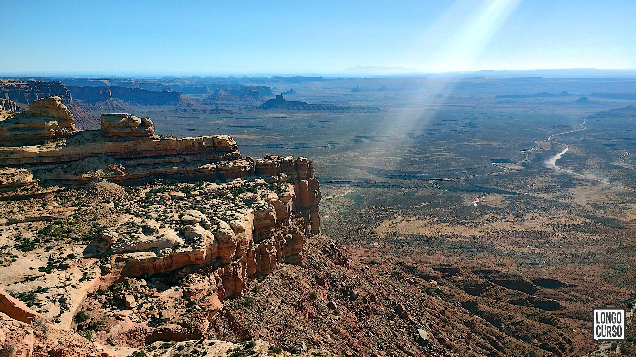 Visual do alto da Moki Dugway. Ao fundo e à esquerda, é possível observar as formações do Valley of the Gods na planície.